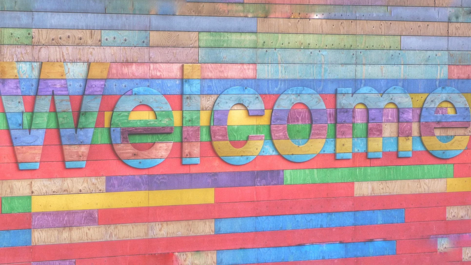 A wooden wall with the word welcome